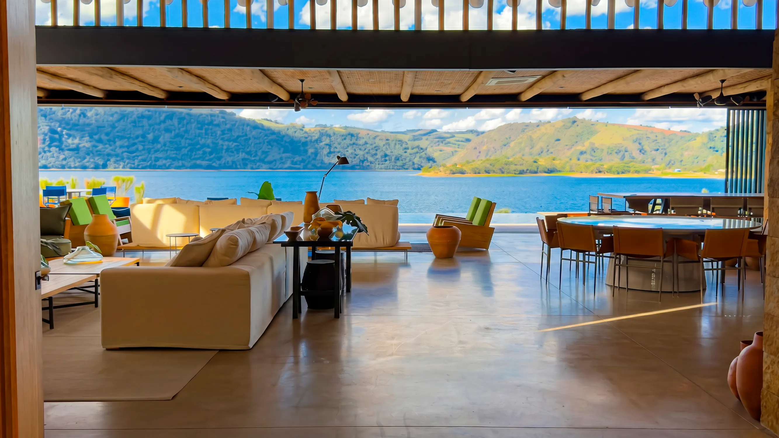 Interior da casa com esquadrias abertas para a Angra Doce e as montanhas